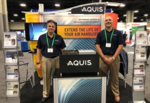 Two AQUIS team members standing at trade show booth