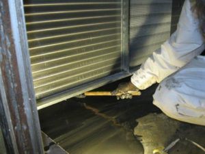 HVAC technician shaping and smoothing engineered epoxy to seal surface on air handling unit