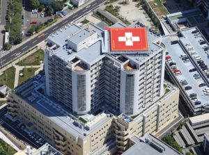 aerial view of hospital with a red helipad on the roof